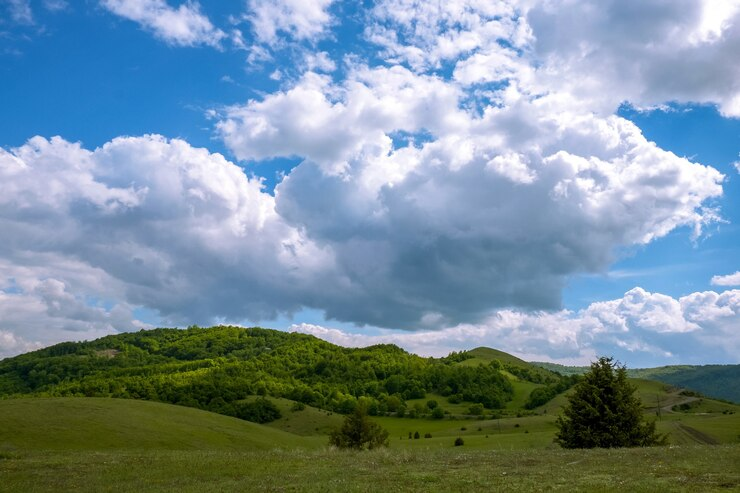 landscape-hills-covered-forests-sunlight-cloudy-sky-daytime_181624-13639